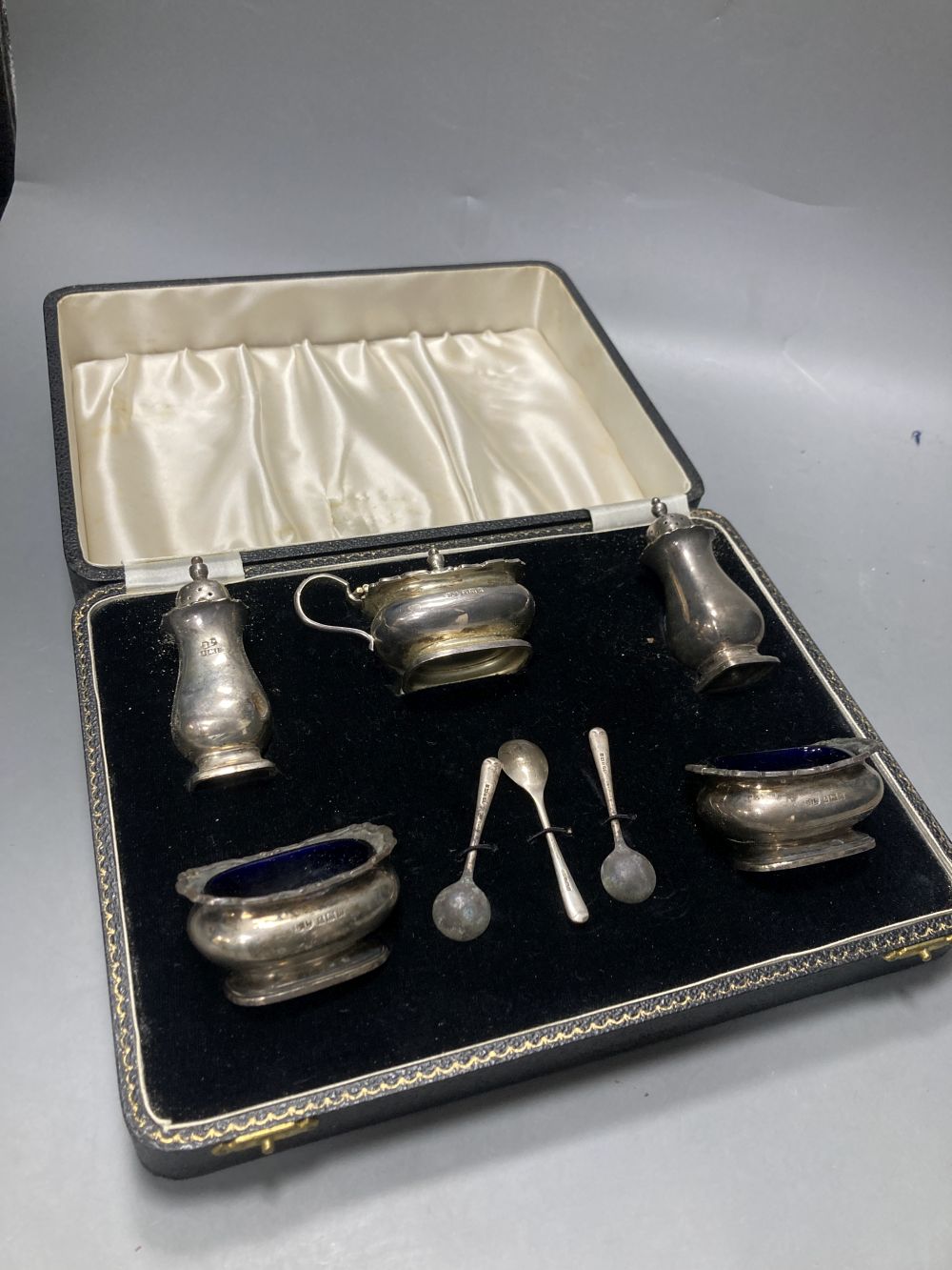 A late 1950s cased silver five piece condiment set, with three spoons, Birmingham, 1957.